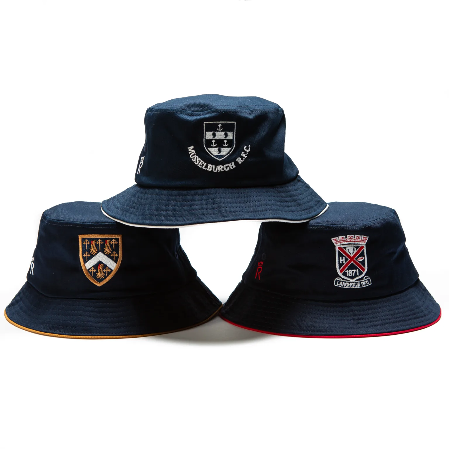 Rex Club | Three navy blue bucket hats are arranged in a triangle. Each hat features a different embroidered crest or emblem on the front, representing various clubs or organizations. | Custom Caps | Custom Hats | Team Headwear | UK