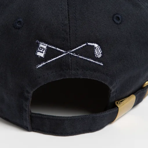 Rex Club | Close-up of the back of the Golf: Quiet Please dark navy cap with embroidered crossed golf clubs and a "19" flag, featuring an adjustable brass buckle strap. | Custom Caps | Custom Hats | Team Headwear | UK