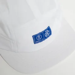 Rex Club | Running Caps: White baseball cap with a blue rectangular patch featuring white symbols and 