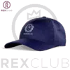 Rex Club | A navy blue baseball cap named "North Berwick RFC Stretch (Copy)" with a white embroidered crest is shown in front of a background featuring the "REXCLUB" logo in large purple letters and a crown graphic. | Custom Caps | Custom Hats | Team Headwear | UK
