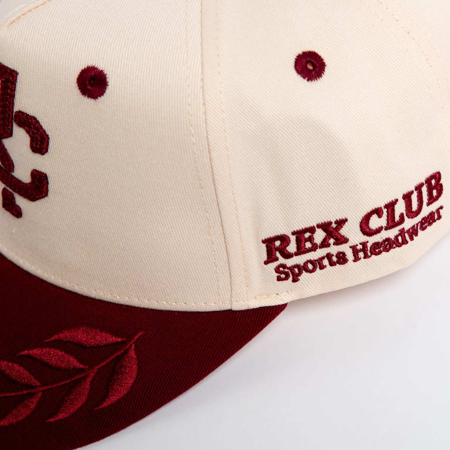 Rex Club | The Rex Club - TwoTone - Canvas Cap features a cream and maroon design with "REX CLUB Sports Headwear" embroidered in maroon on the front and a maroon leaf detail on the brim. | Custom Caps | Custom Hats | Team Headwear | UK