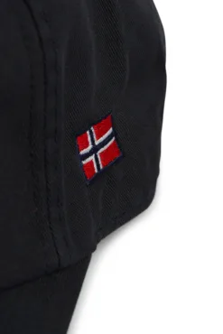 Rex Club | A close-up of the Norway Rugby Stretch cap, showcasing black fabric with a small embroidered Norwegian flag in red, white, and blue. The stitching and fabric texture are clearly visible. | Custom Caps | Custom Hats | Team Headwear | UK