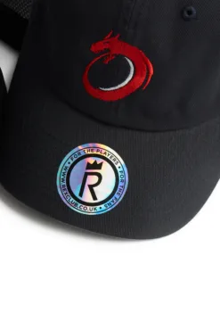Rex Club |  Norway Rugby Stretch | Custom Caps | Custom Hats | Team Headwear | UK Rex Club | The North Berwick RFC Stretch is a black cap with a red dragon logo embroidered on the front and a shiny circular sticker on the brim featuring "RARECLUB.CO.UK," "FOR THE PLAYERS," and a large "R. | Custom Caps | Custom Hats | Team Headwear | UK
