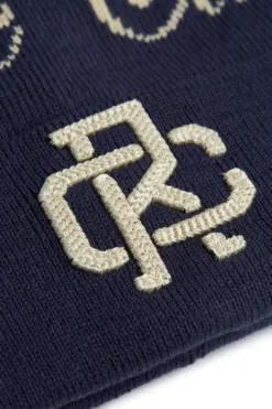 Rex Club | Close-up of the Rex Club Script and Monogram Beanie in navy blue knit, showcasing an embroidered beige intertwined "D" and "C" monogram. | Custom Caps | Custom Hats | Team Headwear | UK