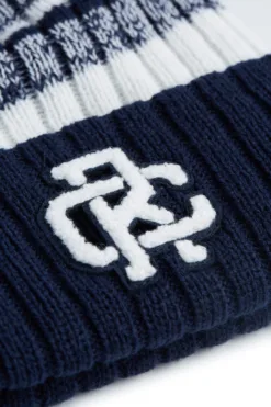 Rex Club | A close-up of the Rex Club Navy/White beanie featuring a chenille RC patch and a white and blue patterned top section. | Custom Caps | Custom Hats | Team Headwear | UK