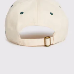 Rex Club | The RC - Two/Tone - SS26 Green is a beige baseball cap viewed from the back, showcasing a fabric strap with a brass buckle and green embroidered eyelets around the crown. | Custom Caps | Custom Hats | Team Headwear | UK