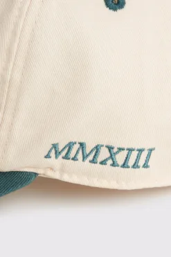 Rex Club | A close-up of the RC - Two/Tone - SS26 Green cap in beige, featuring green embroidery of 