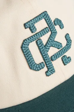 Rex Club | Close-up of the RC - Two/Tone - SS26 Green cap: cream-colored fabric with dark green 