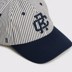 Rex Club | The RC - Baseball Pin - SS26 Navy features a white crown with thin navy vertical stripes, a navy brim and eyelets, and a dark blue embroidered monogram logo on the front. | Custom Caps | Custom Hats | Team Headwear | UK