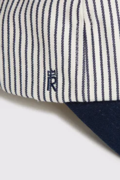 Rex Club | A close-up of the RC - Baseball Pin - SS26 Navy fabric with vertical navy and white stripes, featuring a small embroidered 