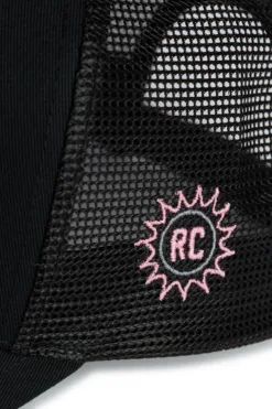 Rex Club | Close-up of the OFFSEASON 26 Trucker cap, featuring black mesh fabric with a pink embroidered sunburst and 